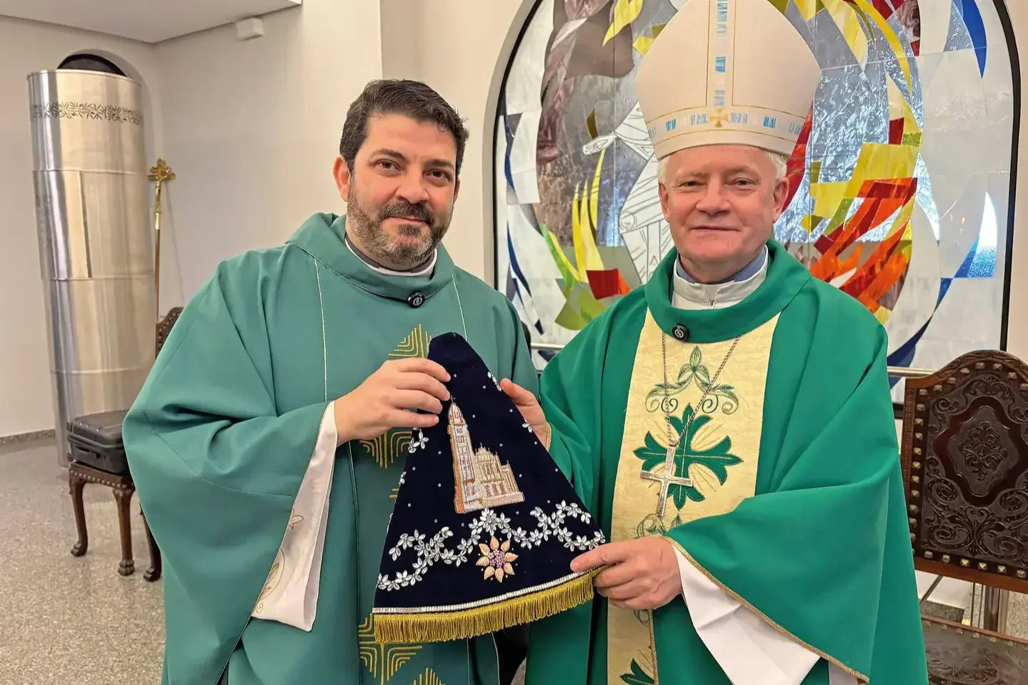Pároco Fábio Dungue e o arcebispo Dom Vilar, com o novo manto (Arquidiocese/Divulgação)
