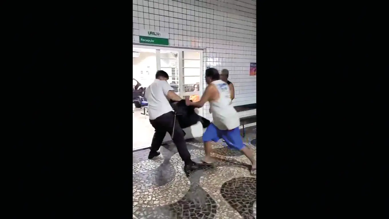 Na UPA Norte, troca de agressões começa na entrada principal da unidade, onde homem entra em luta corporal com um segurança (Reprodução)