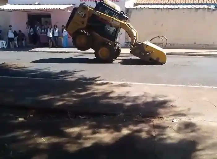Tratorista realiza manobra enquanto alunos assistem (Reprodução)