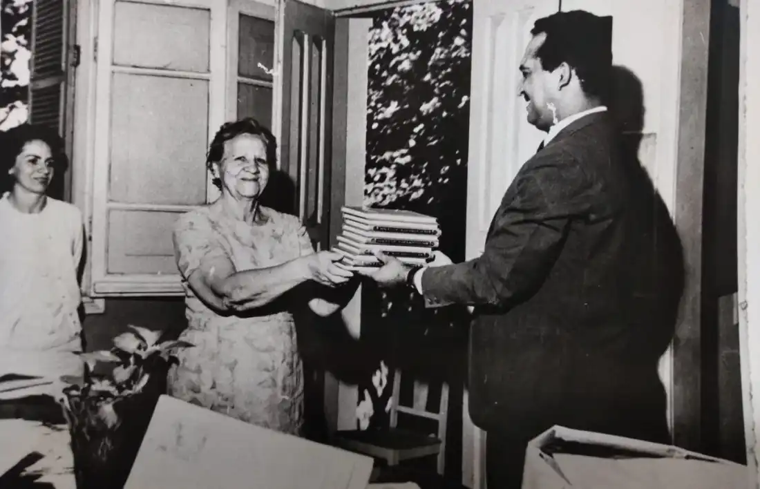Bibliotecária Luiza Marelli recebe doação de livros. Ao fundo Maria José Salles de Morais (Arquivo Público Municipal)