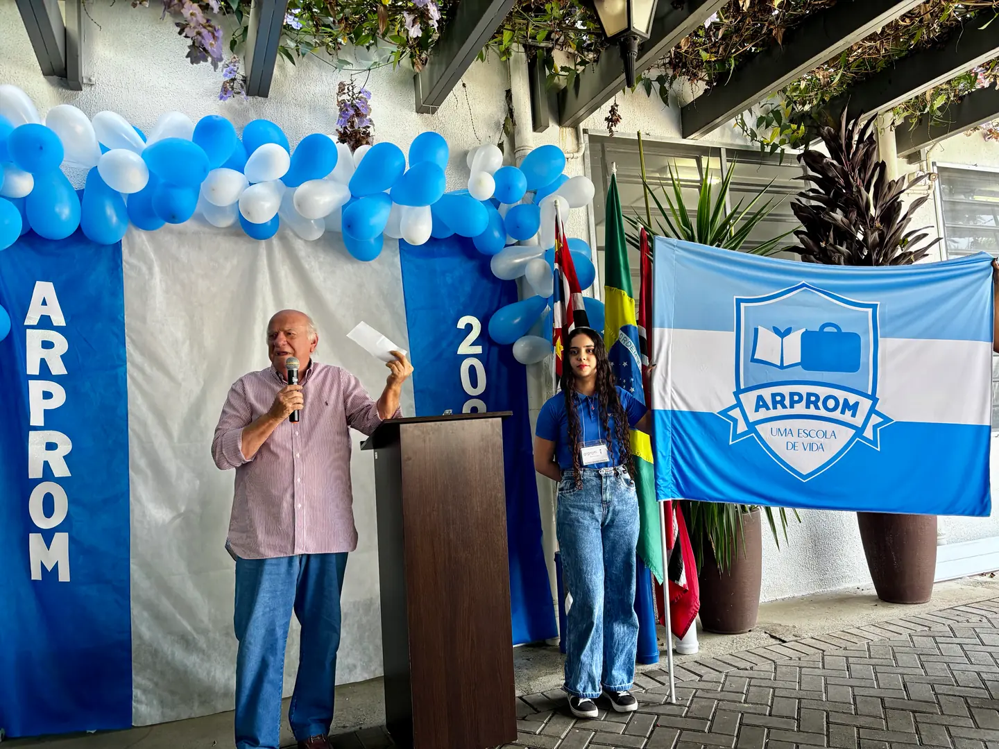 Nicolly Waldemar Brentan, presidente da Arprom, e Beatriz Correia, de 17 anos, com a bandeira (Divulgação)
