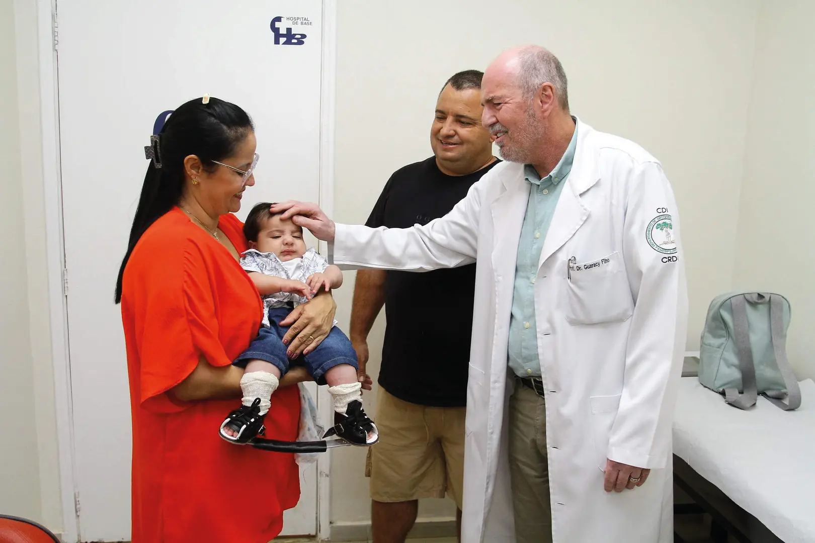 Danila, mãe do Rafael, e o pai Ronaldo, ao lado do professor doutor Guaracy Carvalho Filho, quando o garoto, aos 4 meses, tirou o gesso e colocou a ór (Edvaldo Santos 3/9/2025)