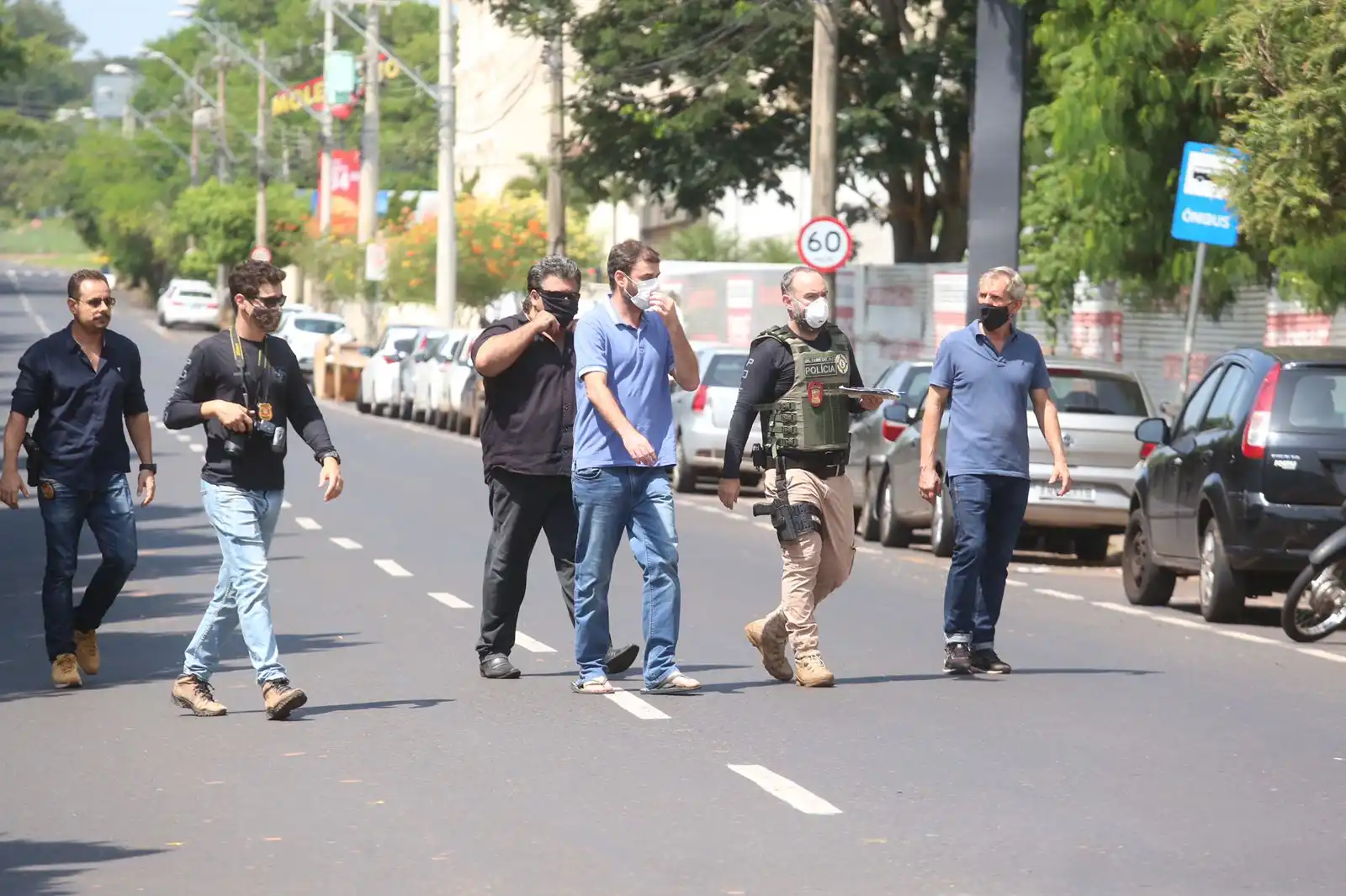 Emerson (de azul, com a mão na máscara) durante reconstituição do crime (Guilherme Baffi 16/2/2022)